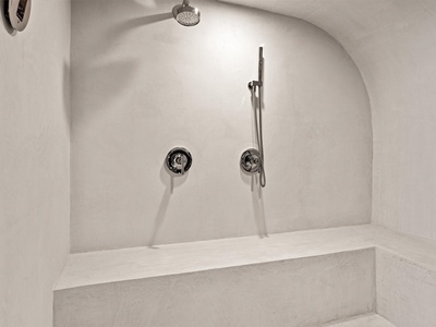 Step into your private spa-like retreat with this spacious walk-in shower featuring dual fixtures and a built-in bench, perfect for unwinding after a day exploring.