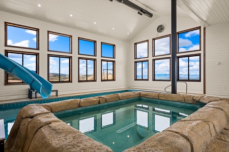 Dive into your private indoor pool surrounded by panoramic mountain and lake views, complete with a fun waterslide for unforgettable family moments.