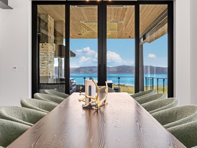 Gather around this stunning table where natural wood meets breathtaking lake and mountain vistas, creating the perfect backdrop for your memorable meals together.