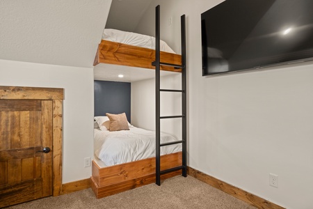 Your cozy bunk room offers rustic charm with warm wood details and crisp white linens, perfect for families or groups. The modern ladder leads to peaceful rest after your mountain adventures.