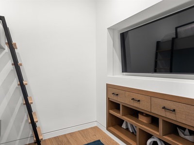 A minimalist entryway welcomes you with clean lines and smart storage. Tuck your belongings in the wooden bench and unwind in your modern retreat.