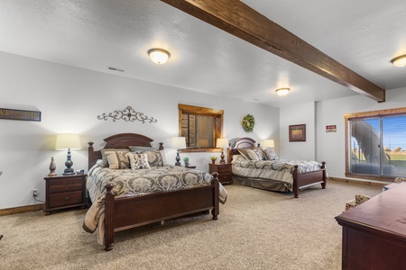 Averon Lodge - Bear Lake Luxury Rentals. Rest peacefully in your spacious bedroom featuring two comfortable beds, rustic wood beams, and charming mountain lodge décor that makes you feel right at home.