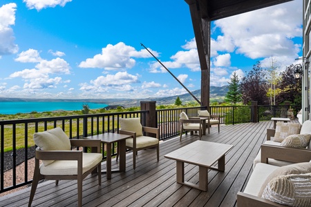 A spacious balcony framed by stunning lake and mountain vistas, with comfortable seating perfect for soaking in the serene natural landscape stretching to the horizon.