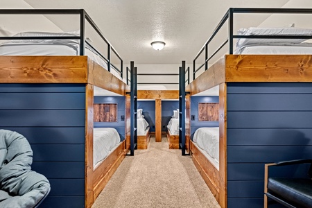 Your group will love this cozy bunk room with beautifully crafted wooden bunks and rich navy accents. Perfect for kids or friends to share—everyone gets their own space for a restful night.