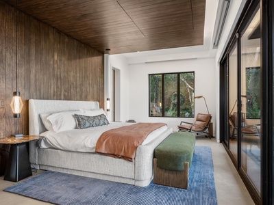 Sink into plush linens and wake to garden views framed by sleek windows. Your bedroom blends modern design with warm wood tones, offering a serene retreat after each day's adventures.