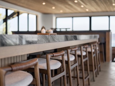Settle in at this inviting communal dining space with warm wood tones and abundant natural light filtering through panoramic windows, perfect for sharing meals and stories.