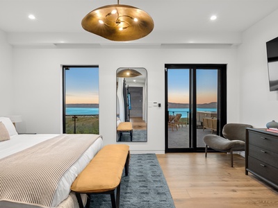Wake up to breathtaking water views framed by floor-to-ceiling windows in your serene, modern bedroom. Step onto your private terrace and let the tranquil scenery become part of your morning ritual.