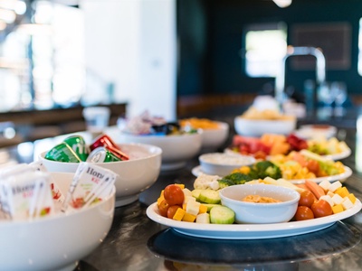 Fresh veggies, vibrant fruit platters, and individual yogurt cups await you—a colorful, healthy spread to start your day perfectly.