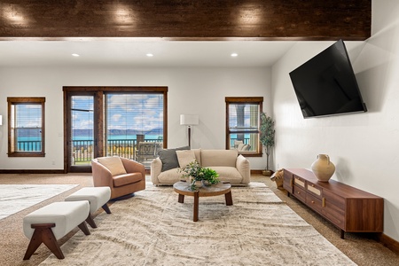 Sink into plush seating beneath warm wood-beam ceilings, where floor-to-ceiling windows frame serene views and natural light fills your stylish living space.