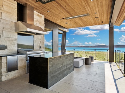 Grill your favorite meals in this stunning outdoor kitchen while soaking in breathtaking lake and mountain views. The covered space keeps you comfortable as you cook and dine al fresco.