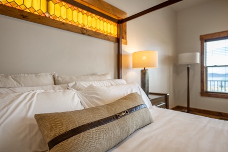 Drift off under a stunning stained glass canopy that casts a warm amber glow over your plush bedding. Thoughtful lighting and handcrafted details create a serene retreat where comfort meets artistry.