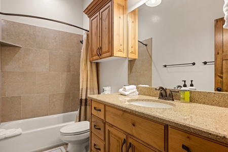 Unwind in your spa-inspired bathroom with a soaking tub, rainfall shower, and warm wood cabinetry—plush towels and bath essentials are all set for your arrival.