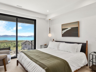 Wake up to stunning lake and mountain views from your cozy bedroom. Crisp linens, modern design, and floor-to-ceiling windows frame your peaceful retreat.