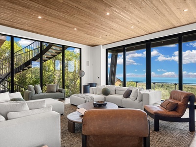 Sink into plush seating beneath soaring wood-planked ceilings as floor-to-ceiling windows frame stunning lake and landscape views—your private sanctuary for unwinding after exploring.