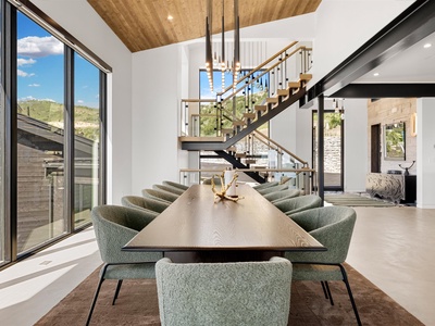 A striking open-concept space featuring sleek architectural design, mountain views through floor-to-ceiling windows, and stylish furnishings that blend modern comfort with natural warmth.