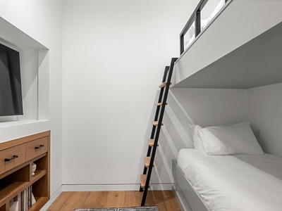 Space-smart comfort for the whole family—your own modern bunk setup with crisp linens and sleek storage below.
