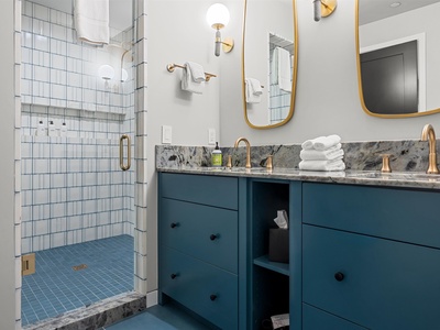 Refresh after your adventures in this modern bathroom featuring a spacious tiled shower, elegant granite counters, and plush towels awaiting your arrival.