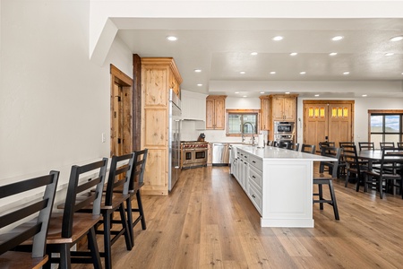Your spacious chef's kitchen welcomes you with gleaming countertops, a generous island, and warm wood tones throughout. Gather around the table or perch at the bar—there's room for everyone to share meals together.