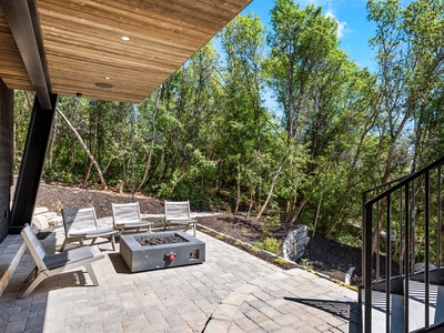 Unwind on your private patio with a fire pit, surrounded by lush trees and peaceful natural landscape—perfect for morning coffee or evening conversation under the open sky.