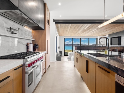 Your modern chef's kitchen opens to stunning lake views, inviting you to cook with natural light streaming through expansive windows. Sleek countertops and high-end appliances make meal prep effortless.