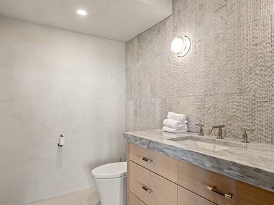 Step into your modern, spa-like bathroom with sleek stone countertops, designer tile work, and soft lighting that creates the perfect retreat after a day of exploring.