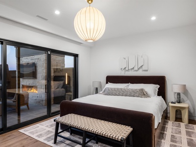 You'll drift off beneath a sculptural pendant light, wrapped in soft linens. The sliding doors open to your private courtyard with a glowing fireplace, perfect for quiet evenings.