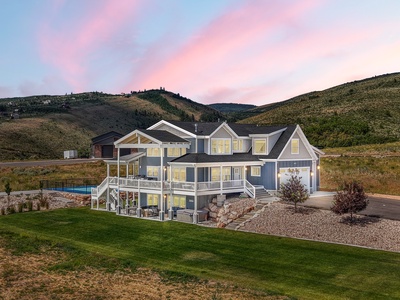 Spectacular mountain estate featuring modern architecture with expansive decks, swimming pool, and stunning sunset views over rolling hills.