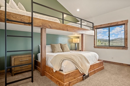 Cozy up in this thoughtfully designed bedroom with a custom bunk bed and open mountain vistas framed perfectly by the window.