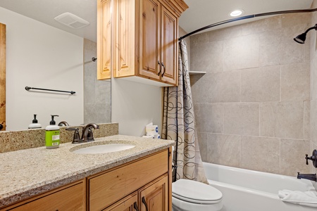 Refresh in your pristine bathroom with modern granite counters, warm wood cabinetry, and a spotless tub-shower combo—comfort and convenience just steps from your bedroom.