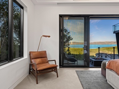 Your serene retreat offers crisp modern design where a comfortable leather chair invites you to relax with stunning lake and mountain vistas just beyond your private balcony.