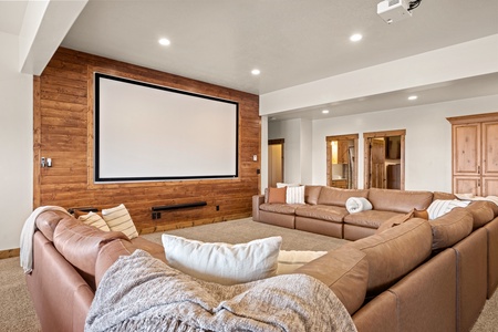 Settle into plush leather seating and enjoy movie nights on your own private projector screen, complete with warm wood accents and cozy throws for the ultimate home theater experience.