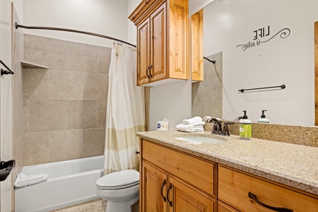 Your private bathroom features warm wood cabinetry, granite countertops, and a full tub-shower combo—everything you need to refresh after a day of adventure.