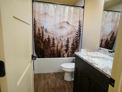 Unwind in your stylish bathroom featuring a mountain forest shower curtain that brings nature indoors, paired with elegant marble countertops.