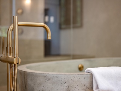 Slip into your private soaking tub for a luxurious soak. The elegant gold fixtures and plush towels await your ultimate relaxation moment.