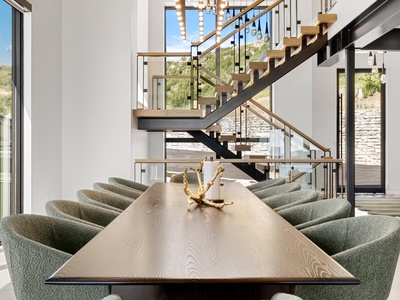 Gather around this stunning dining table, where natural light pours through soaring windows and modern elegance meets warm wood tones. The open layout invites conversation and connection.