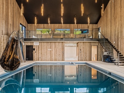 Your private indoor pool awaits, surrounded by sleek wood paneling and modern lighting. Dive in, relax on the mezzanine, or glide down the slide for pure vacation fun.