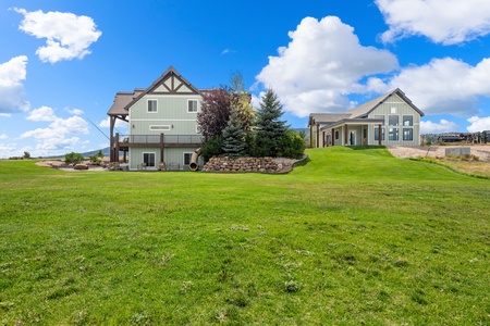 A peaceful countryside property with expansive lawns and mountain views, offering quiet seclusion and charming architectural details across two buildings set on manicured grounds.