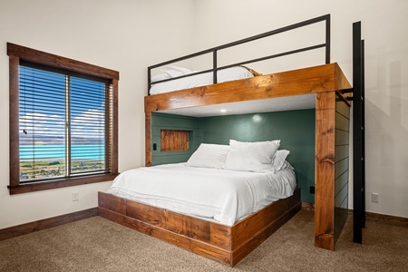 Your cozy bunk room features handcrafted wooden beds with crisp white linens, perfect for kids or groups sharing a space—and you can wake up to stunning ocean views right outside your window.