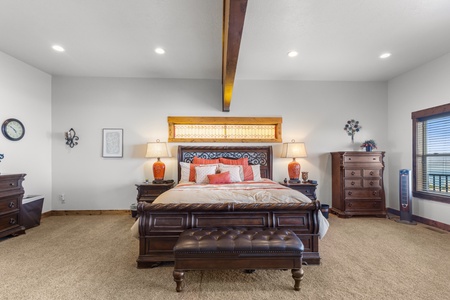 Averon Lodge - Bear Lake Luxury Rentals. Unwind in your elegant master bedroom featuring rich wood furnishings, soft lighting, and luxurious bedding for the perfect night's rest.