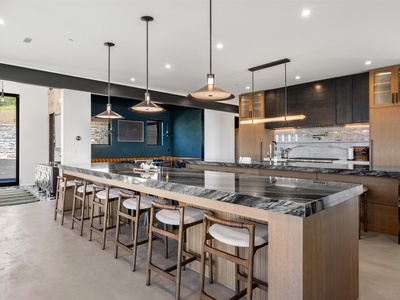 A sleek communal kitchen with stunning marble countertops, designer pendant lighting, and bar seating where you can gather with friends over meals and conversation.