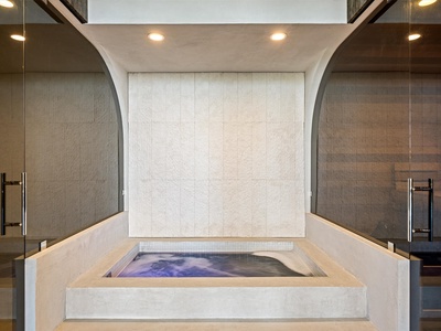 Sink into your private sunken hot tub framed by sleek concrete and warm lighting—a modern spa sanctuary just for you.