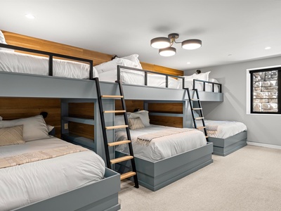 This spacious bunk room sleeps the whole crew with plush bedding, modern wood-and-metal bunks, and plenty of natural light for your mountain getaway.
