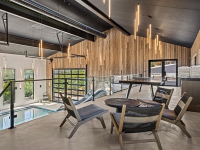 Gather around the table for games or unwind in sleek modern chairs while enjoying views of the indoor pool through floor-to-ceiling windows.