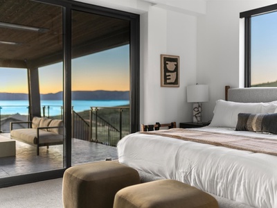 Wake up to breathtaking lake vistas framed by floor-to-ceiling windows. Your luxurious bedroom opens to a private balcony, inviting you to sip morning coffee as soft light spills across crisp linens and contemporary furnishings.