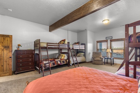 Averon Lodge - Bear Lake Luxury Rentals. Gather your family in this cozy bunk room where kids can create memories while you relax in the comfortable armchair nearby.