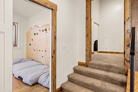 A bright multi-level space showcasing exposed wood beams and a kids' climbing wall, perfect for active families seeking adventure indoors.