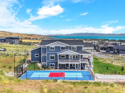 A stunning multi-level home with private sport court overlooking breathtaking lake and mountain views in a peaceful hillside setting.