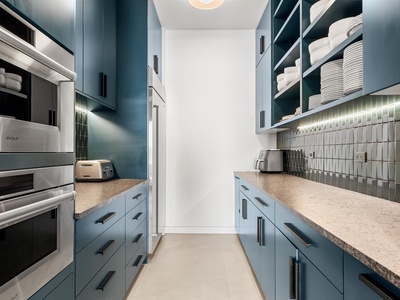 Your sleek galley kitchen features high-end appliances, elegant blue cabinetry, and everything you need to whip up delicious meals during your stay.
