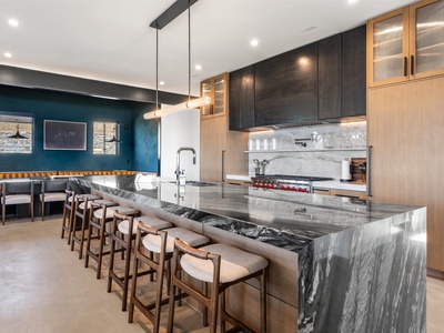 Gather with friends at this stunning kitchen island featuring dramatic marble, professional-grade appliances, and generous seating for effortless entertaining.