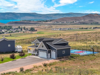 Spacious property with tennis court nestled in scenic mountain valley near pristine lake waters.